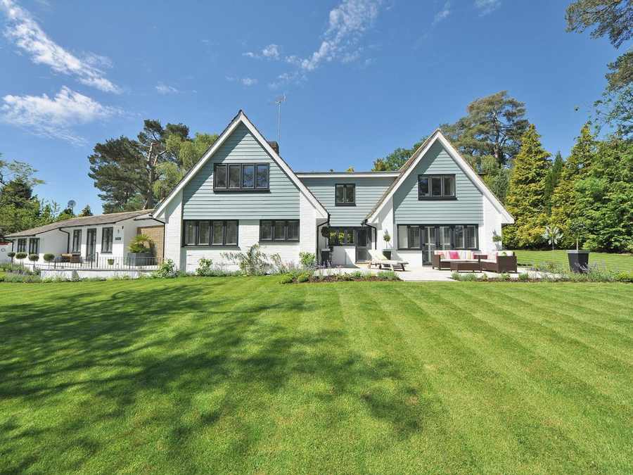 Einfamilienhaus mit Rasen und Bäumen